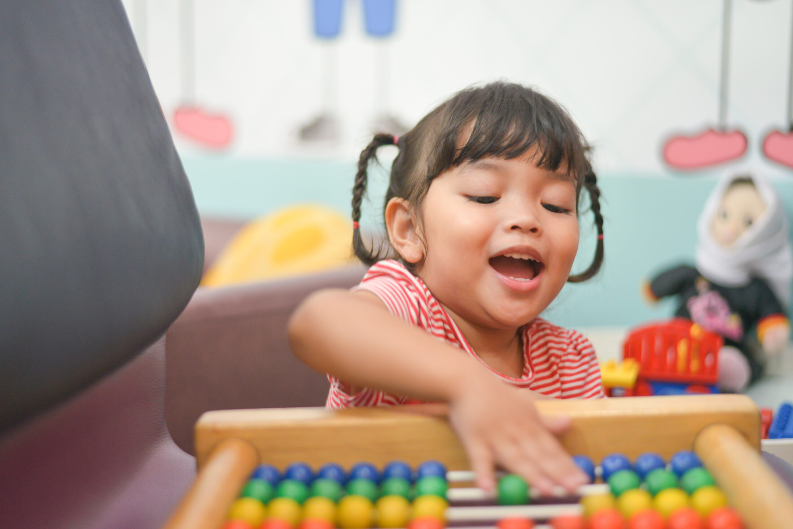 Cute Asian little kid girl playing with abacus at home. Smart ch